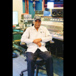 Elderly man seated in recording studio