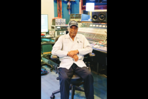 Elderly man seated in recording studio