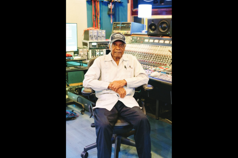 Elderly man seated in recording studio